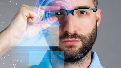 Homme portant des lunettes intelligentes avec des hologrammes et des données numériques flottantes.