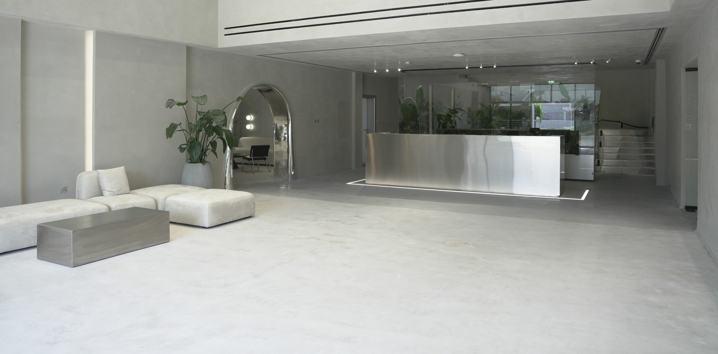 Double-height entrance lobby with mirrored arch and steel reception, creative studio, JAFZA