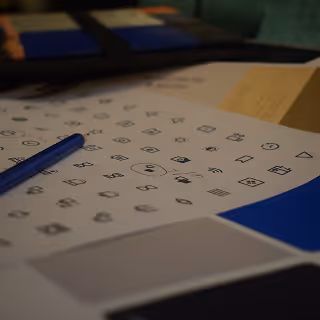 Visual acuity test sheet with various symbol shapes and a blue pen placed on top.