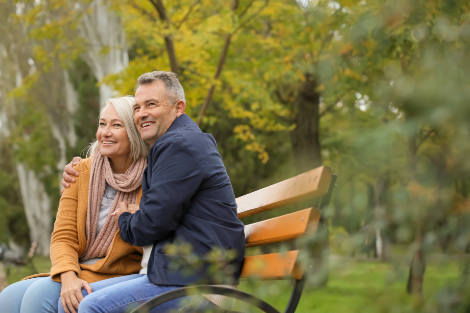 An older couple walking together outdoors in a park — Longevity & Healthspan