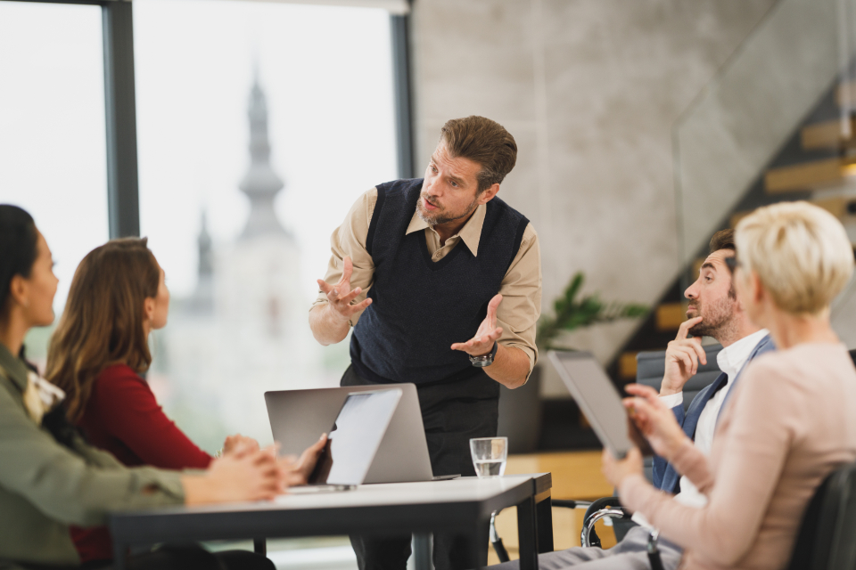 A team in discussion at an office table — Precision Medicine & Genomics