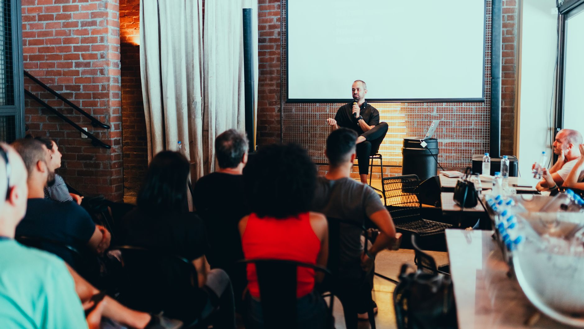 A dynamic seminar with a speaker engaging a diverse audience in a modern indoor setting — Longevity & Healthspan