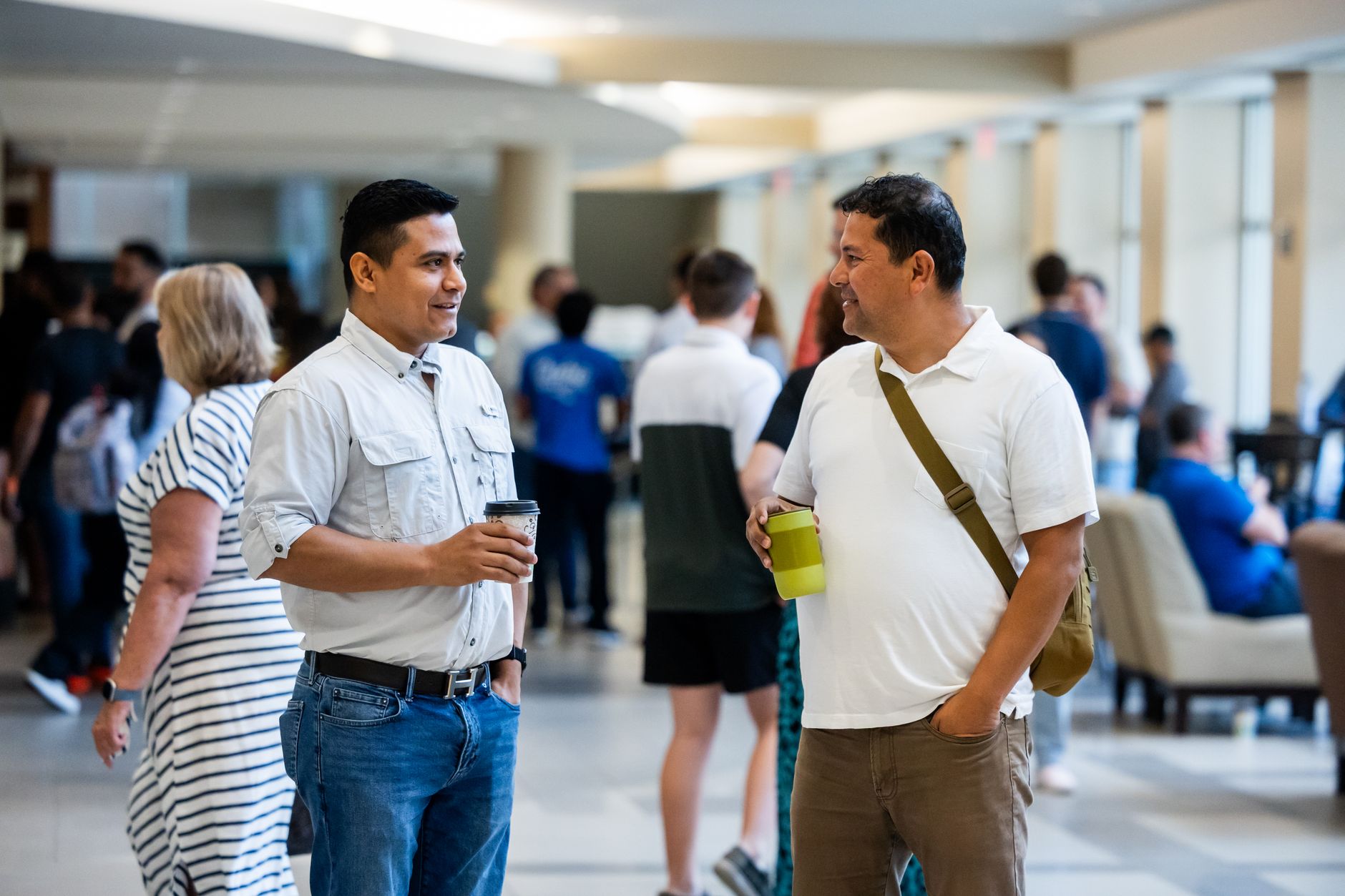 Two adults engaging in casual conversation during an indoor networking event — Longevity & Healthspan