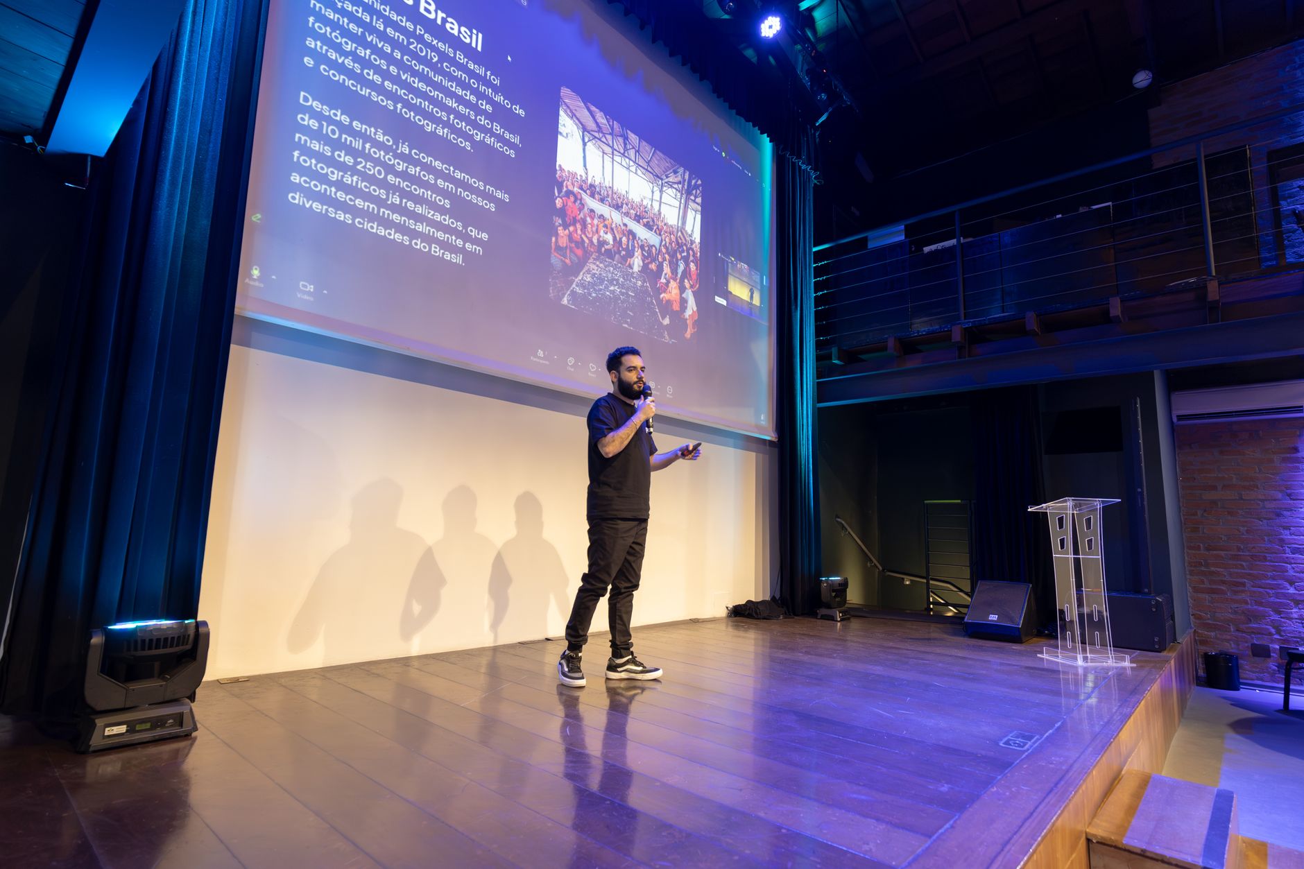 Speaker presenting at a conference with a projected presentation slide on screen — AI & Digital Health