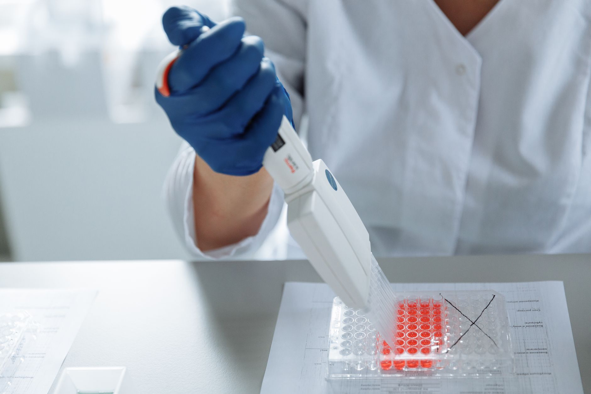 Close-up of a scientist using a pipette in a lab with a focus on sterile procedures — Precision Medicine & Genomics