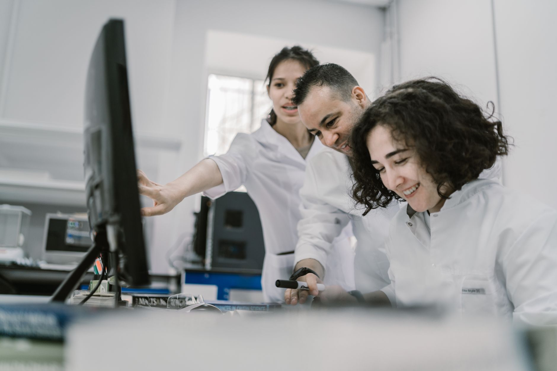 Group of diverse scientists working together on a computer in a bright, modern laboratory — Precision Medicine & Genomics