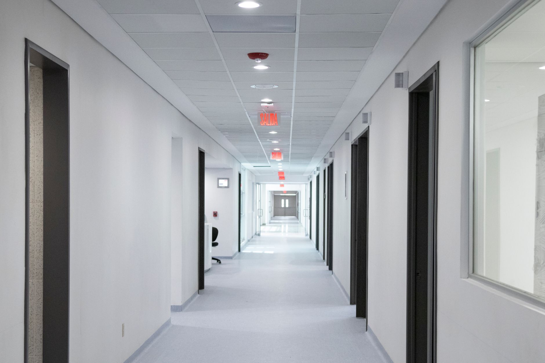 White-walled hospital corridor with modern design and bright overhead lighting — Healthcare Infrastructure