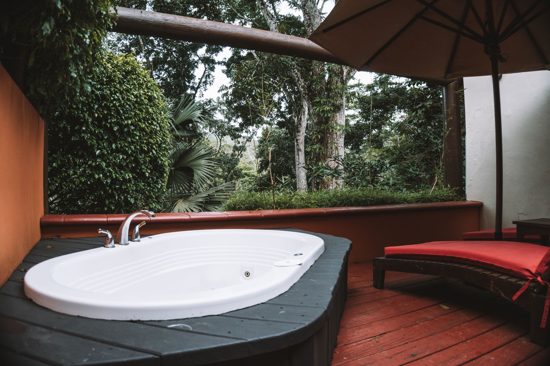 Relaxing outdoor jacuzzi on a luxury terrace surrounded by lush greenery and serene ambiance — Longevity Tourism & Wellness