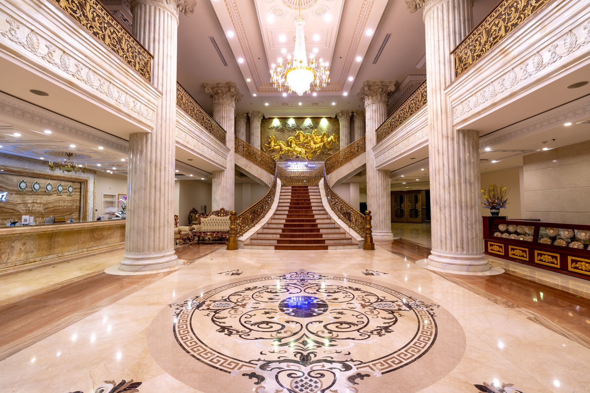 Elegant hotel foyer featuring a grand staircase, marble floors, and a dazzling chandelier — Longevity Tourism & Wellness