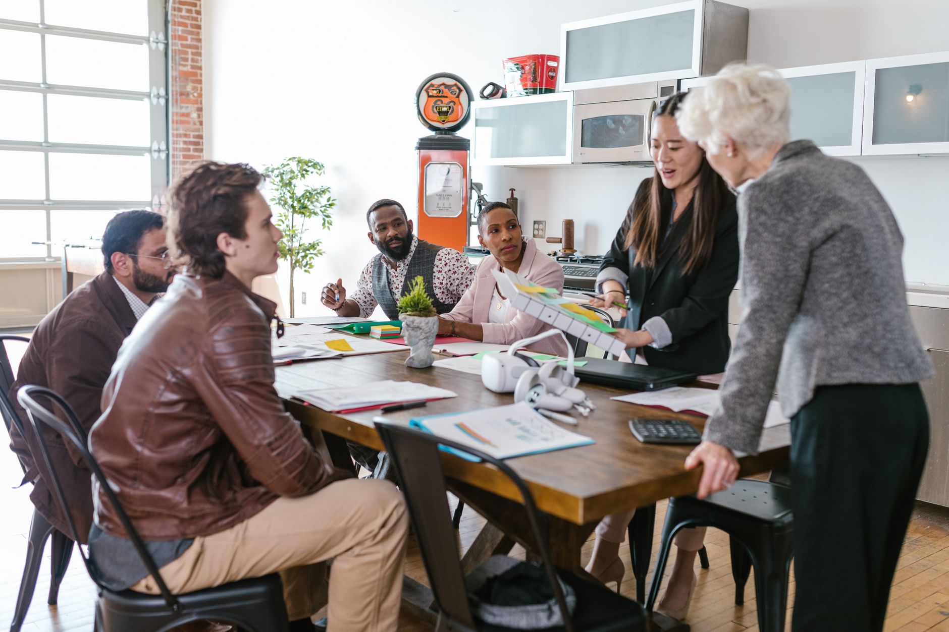 Colleagues engaged in a collaborative business meeting around a table in a modern office setting — Digital Money & Securitization