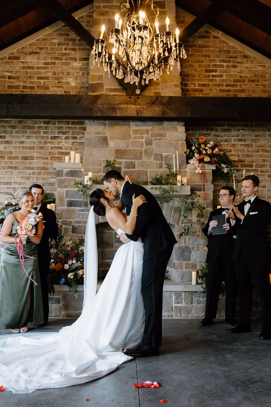 Couple sharing their first kiss during a small indoor wedding ceremony in Pennsylvania, surrounded by loved ones.