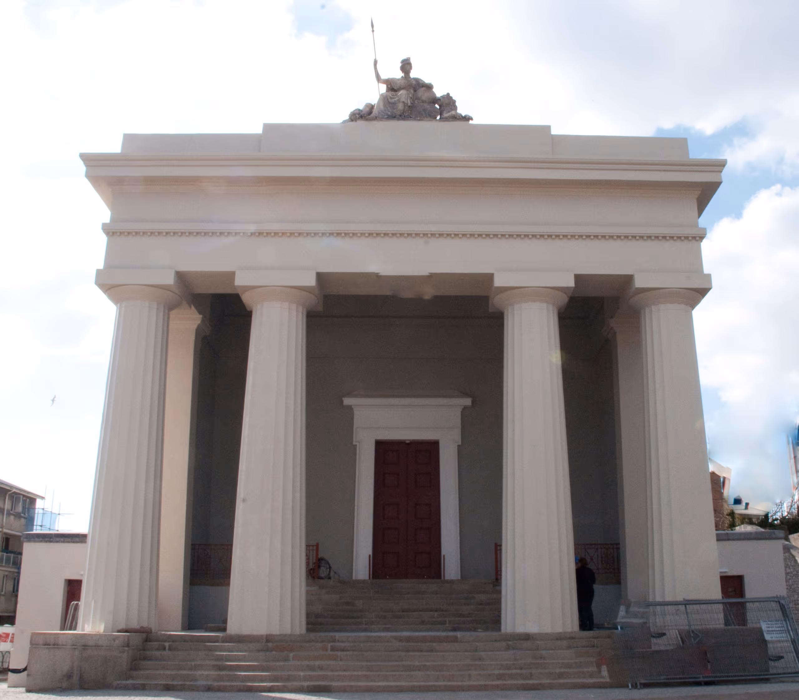 Guildhall building with white columns, triangular pediment, and statue on top after restoration