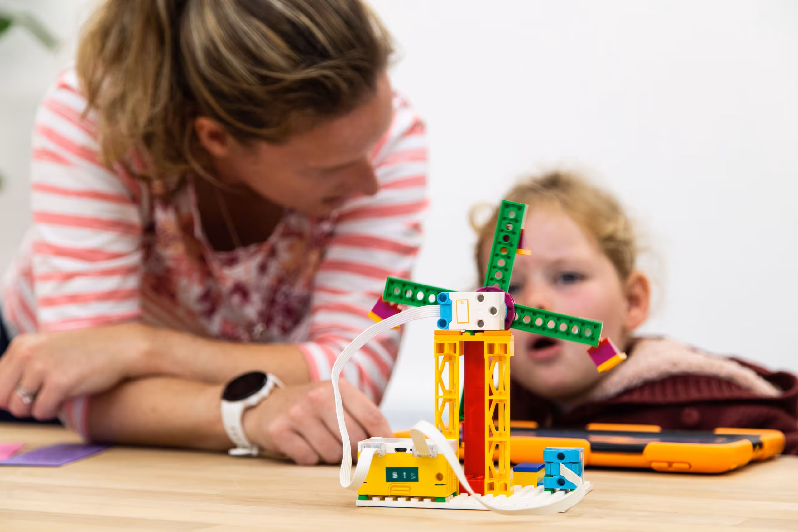 Mother and child working with colorful educational building blocks during library program