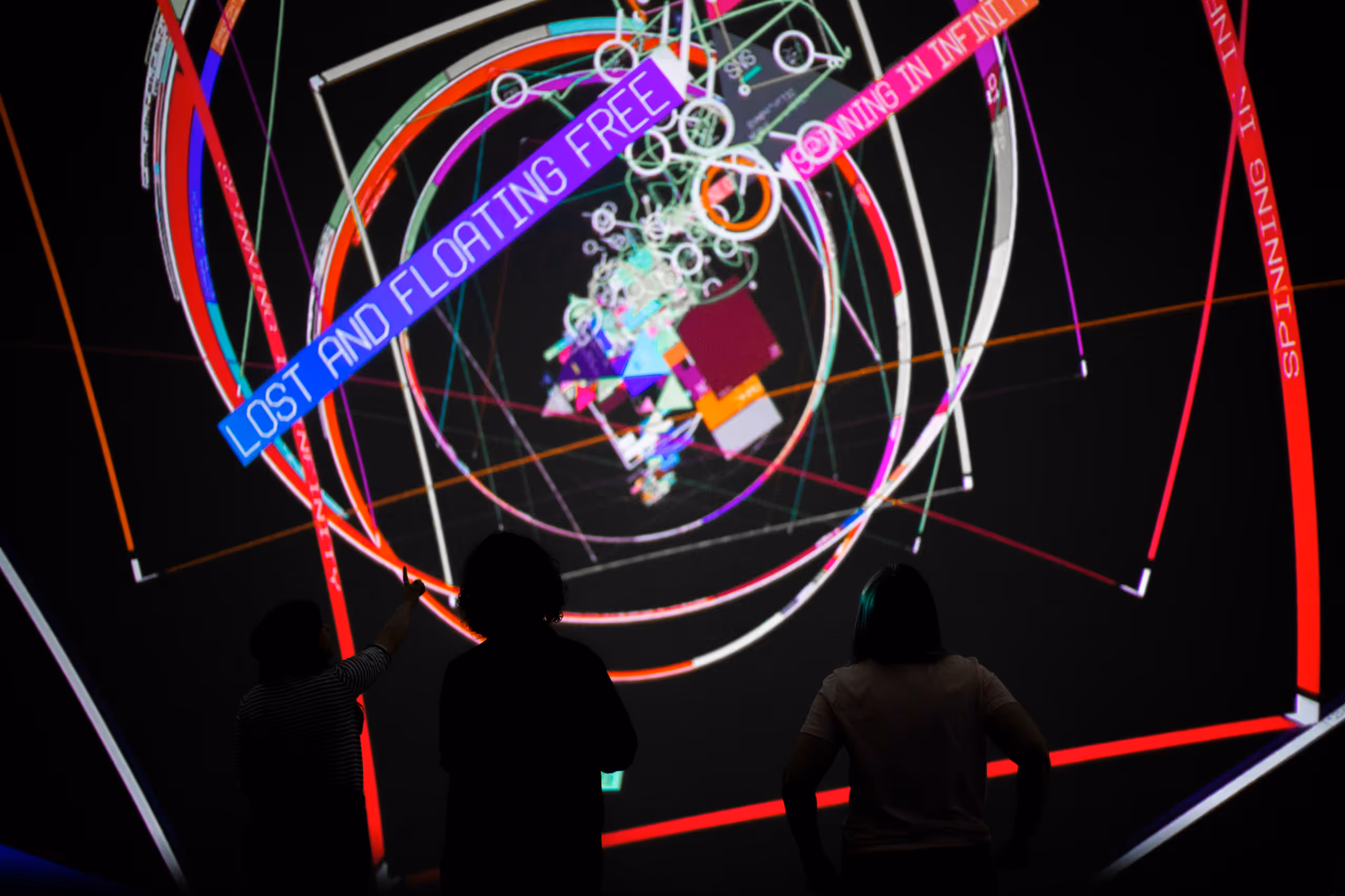 Immersive tunnel display showing "LOST AND FLOATING FREE" text with colorful neon rings