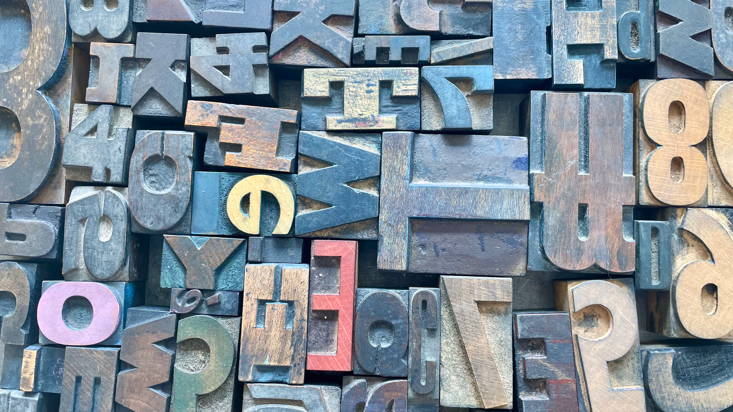 Mixed collection of vintage wooden letterpress type blocks in various colours