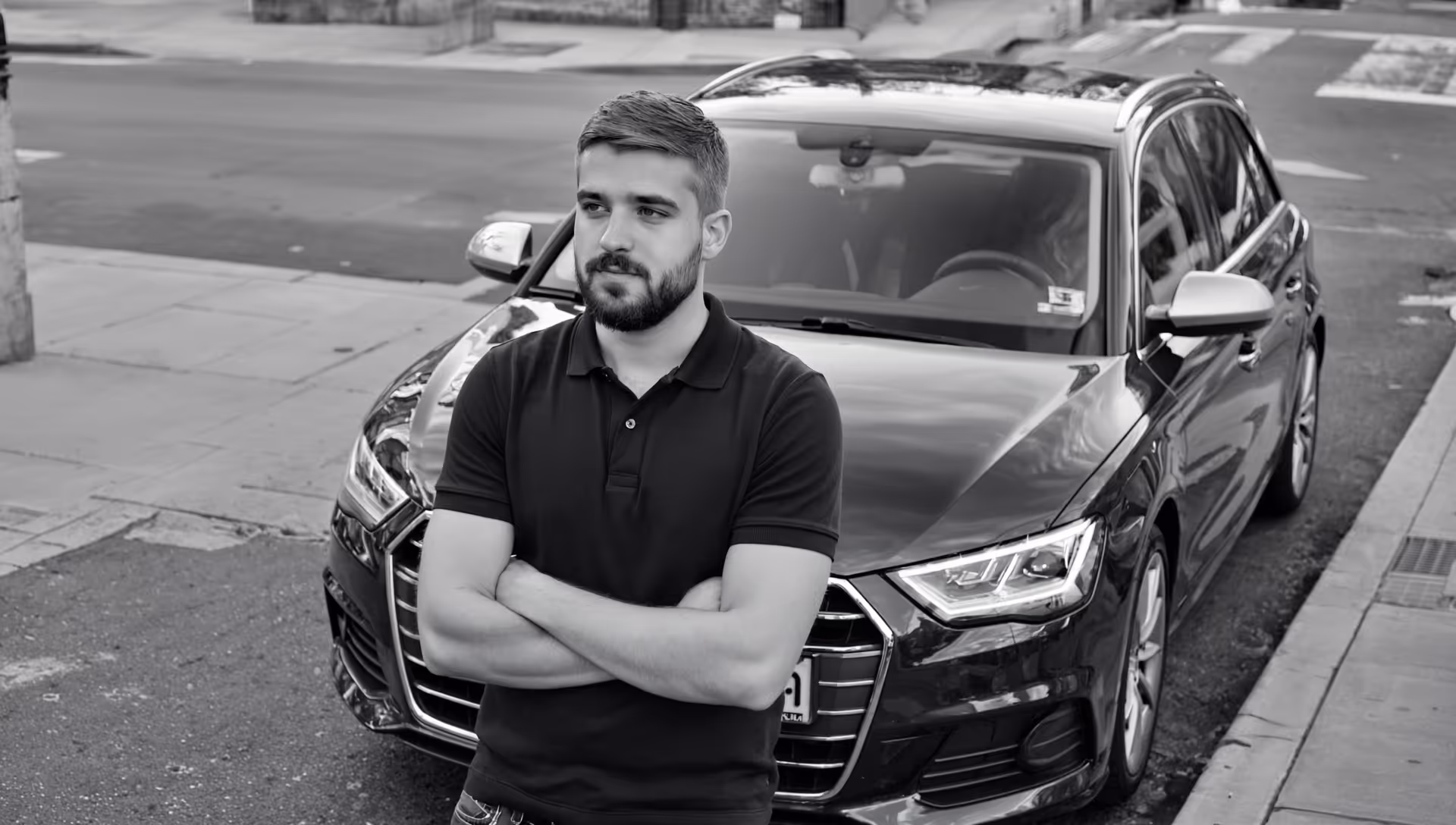 A satisfied customer of grease and oild in front of his black audi after a affordable and reasonable warranty safe service and logbook stamp