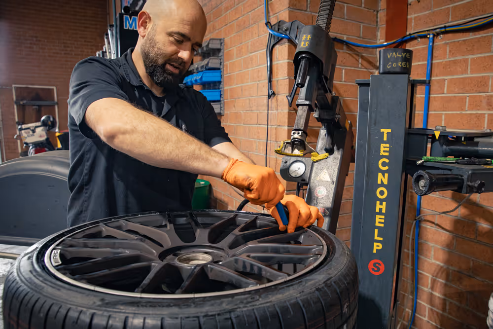 Dom from grease and oil doing a tyre fitment on a mercedes benz amg wheel with a pirelli tyre shop in wollongong cbd 