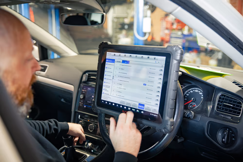 mike from grease and oil automotive wollongong using a scan diagnostic tool on a new car service volkswagen audi group