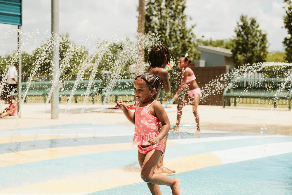 A little girl playing at a Splash Pad party.
