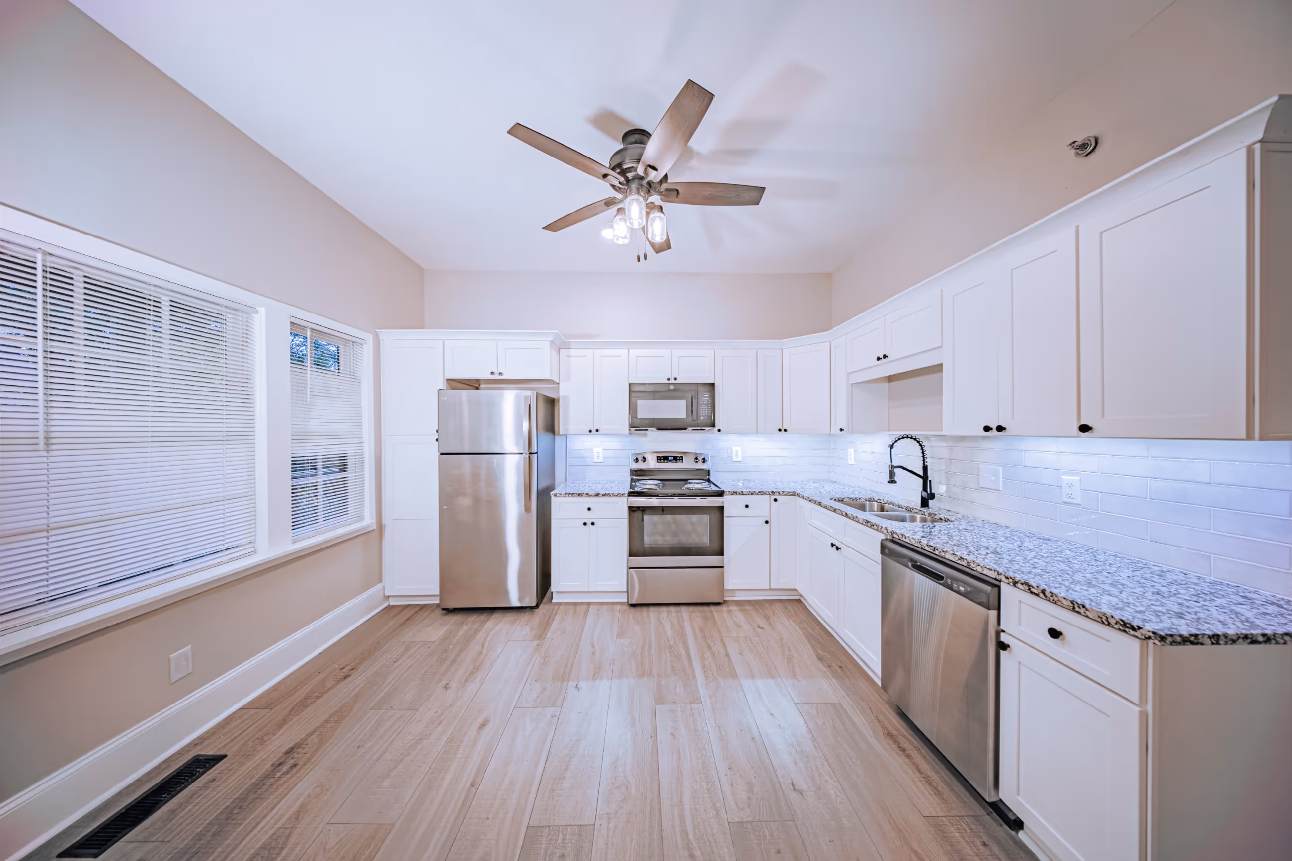 Bright living room with large windows and modern finishes at Victorian Village Apartments in Marietta GA
