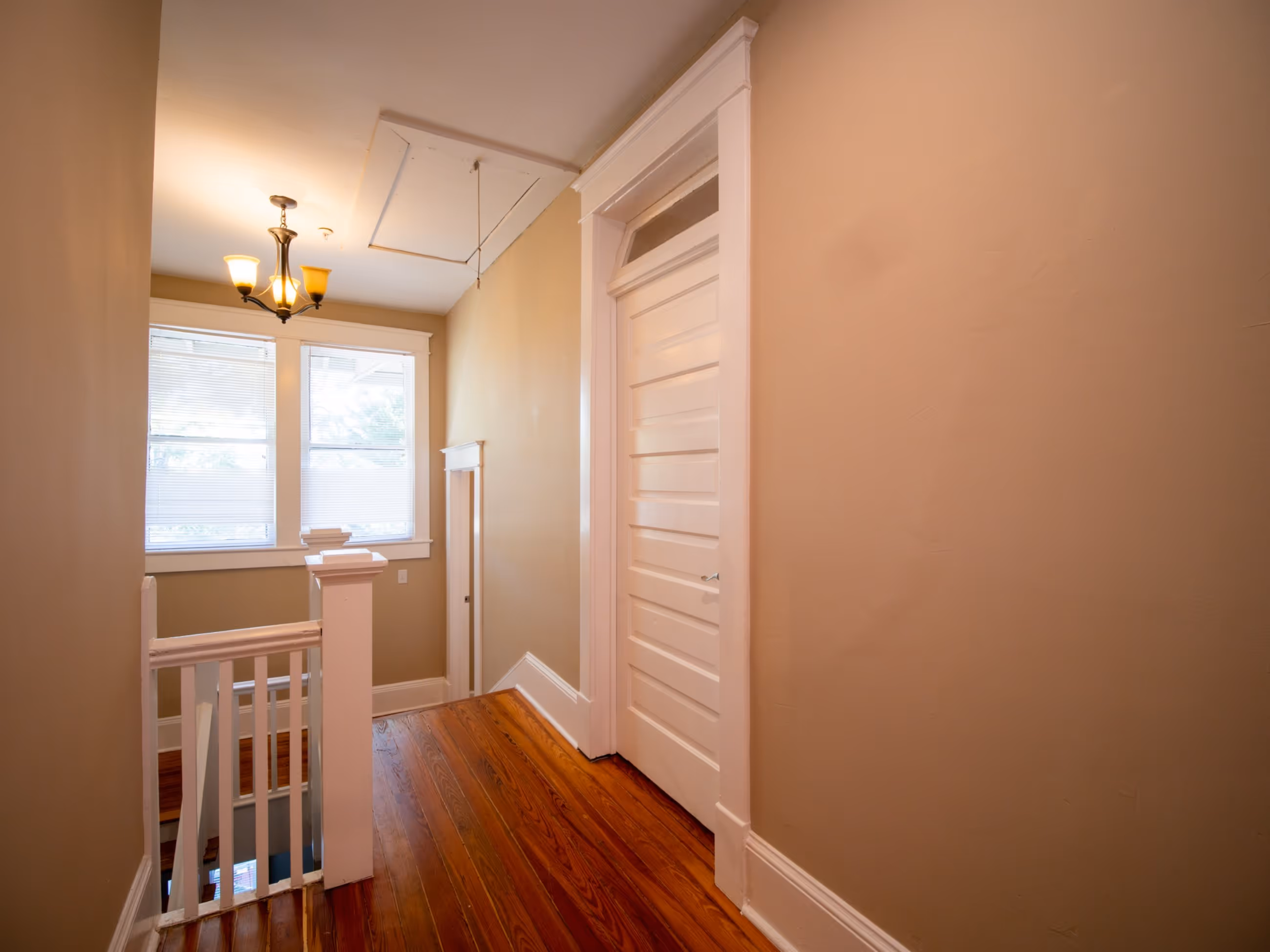 Cozy bedroom with hardwood floors and plantation shutters at Victorian Village Apartments in Marietta GA