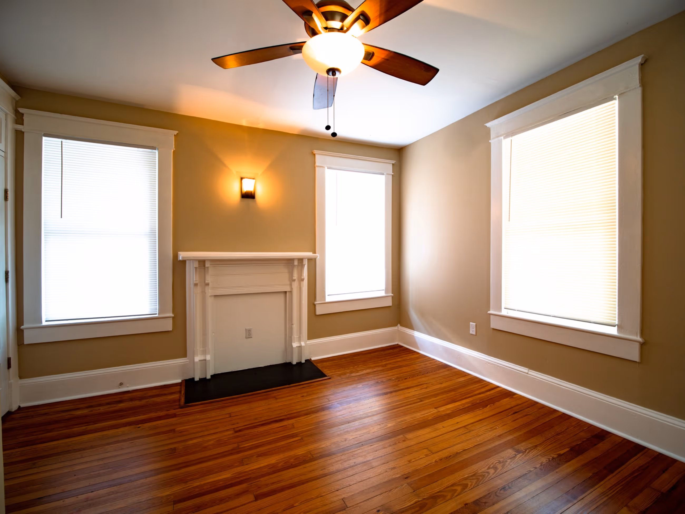 Historic bedroom interior with hardwood floors and ceiling fan at Victorian Village Apartments in Marietta GA