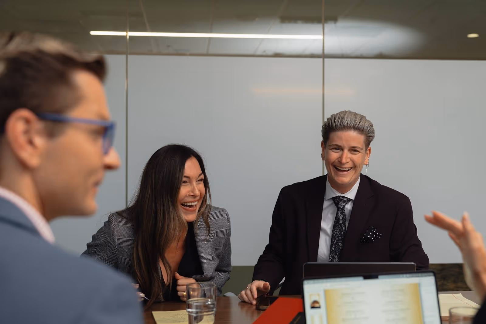 Jillian Duggan-Herd, Kevin Alexander, and colleagues laughing together in the office.