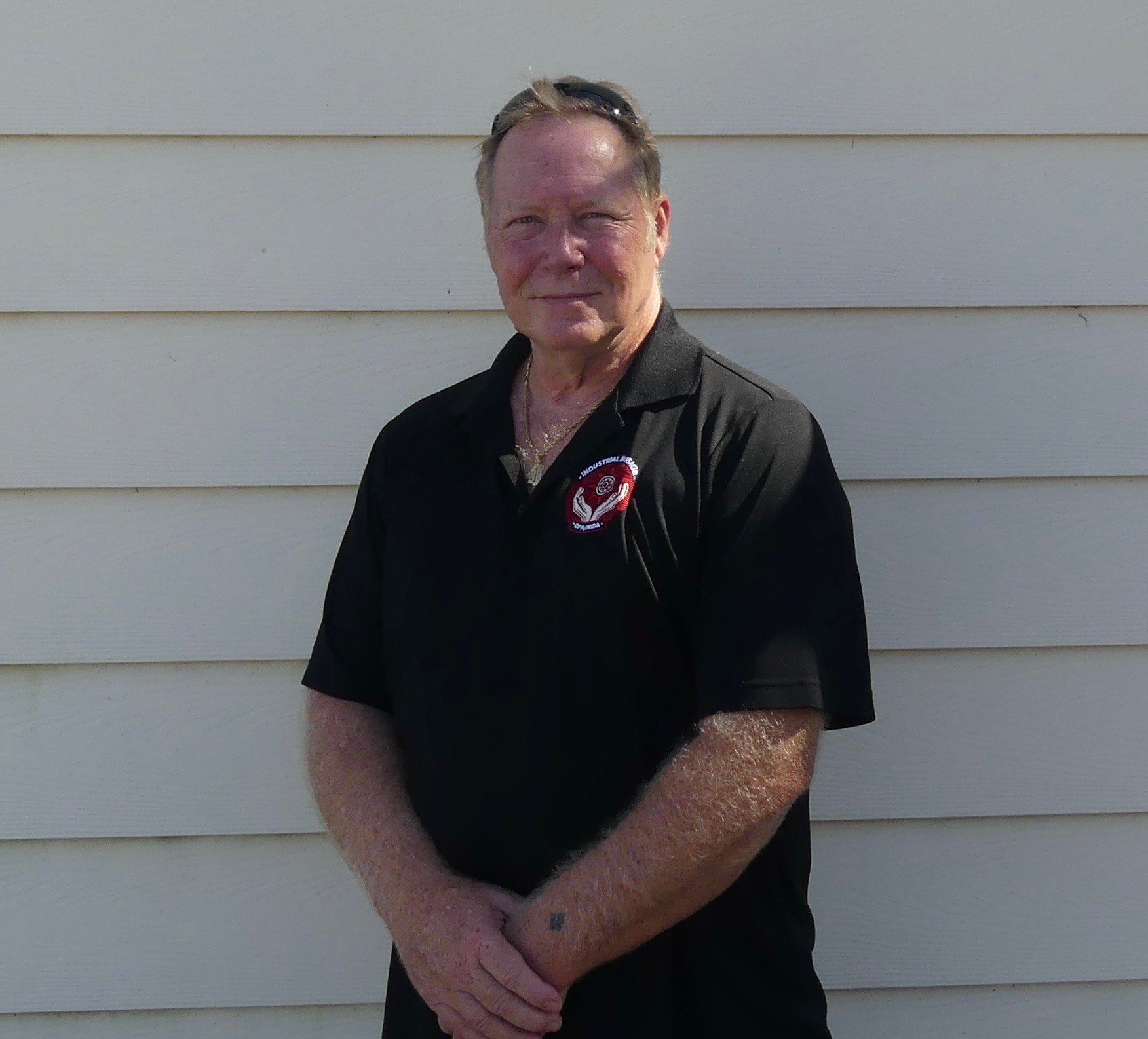 A photo of Eric Wilson standing in front of cream shiplap.