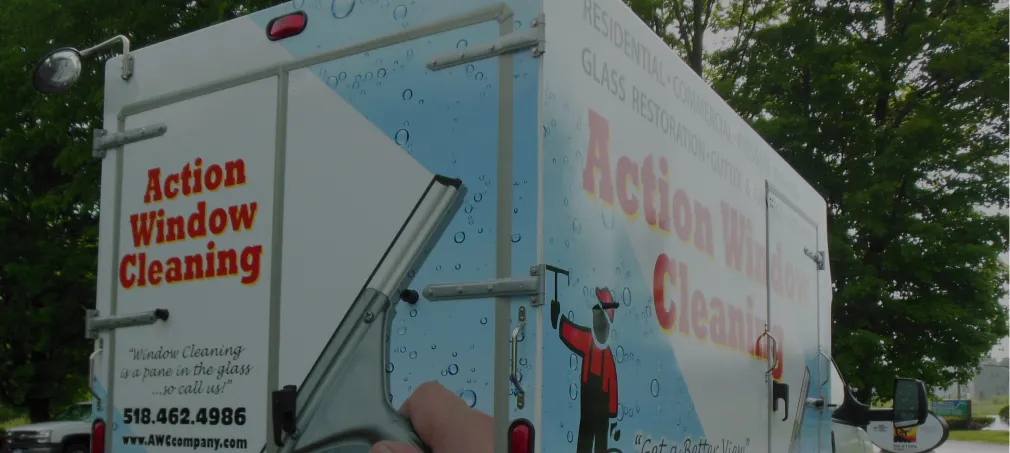 Vehicle wrap for Action Window Cleaning featuring a squeegee graphic, water droplets, and contact info.