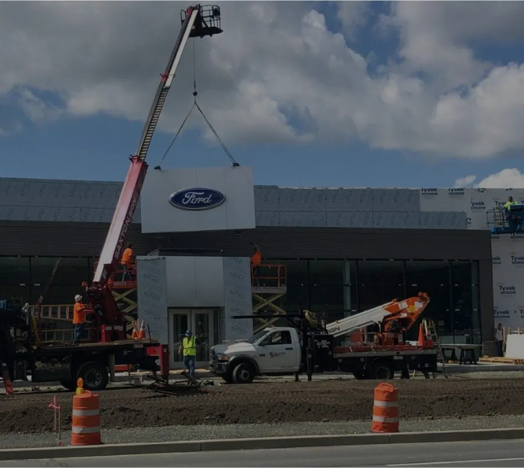 Installation of Ford dealership signage using crane and lift equipment by Saxton Signs team