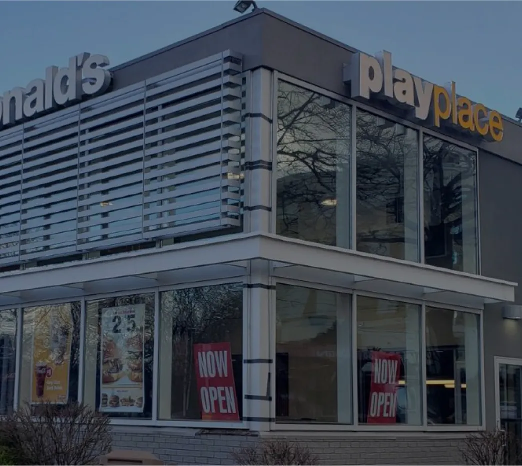 Modern McDonald's Playplace building exterior with large glass windows and Now Open signage