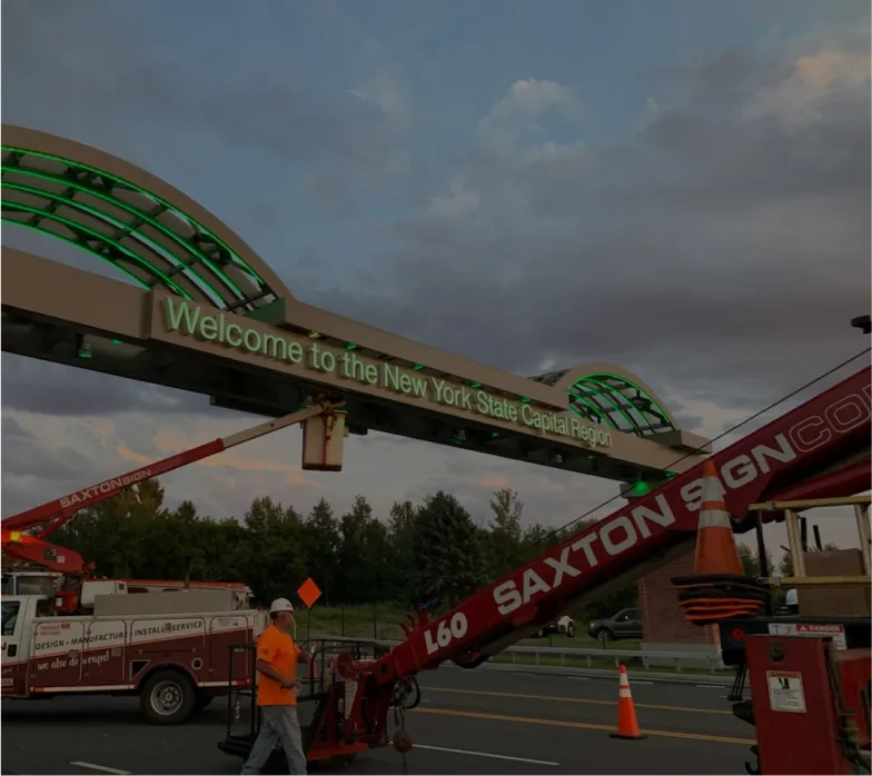 Installation of illuminated "Welcome to the New York State Capital Region" gateway sign by Saxton Sign Company at sunset.