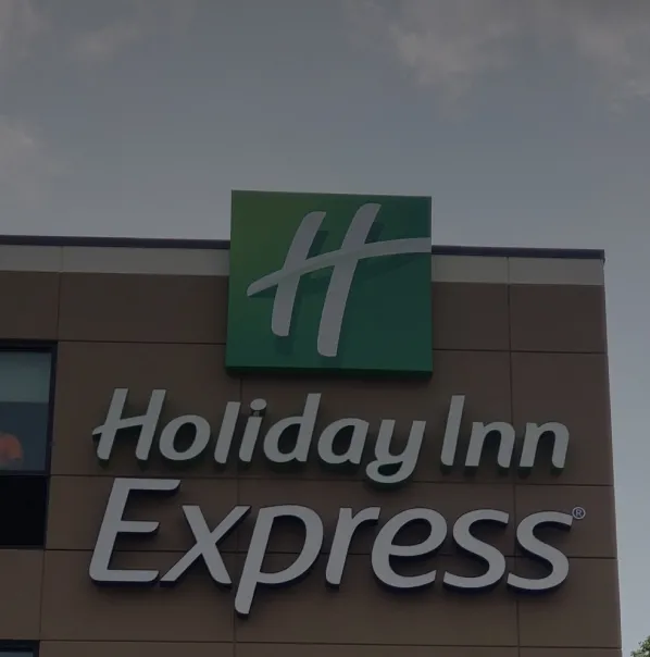 Holiday Inn Express green and white logo sign mounted on hotel building exterior