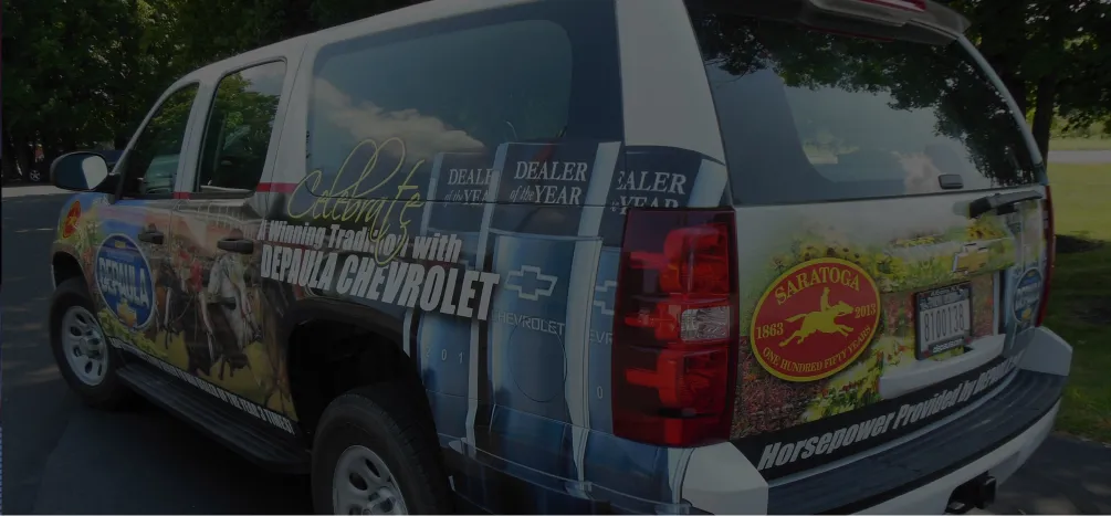 Custom vehicle wrap for Depaula Chevrolet promoting dealership awards and local partnerships.