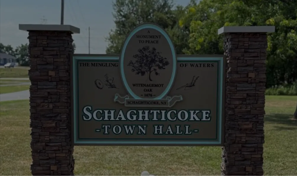 Welcome monument sign for Schaghticoke Town Hall with historical reference and stone pillars.