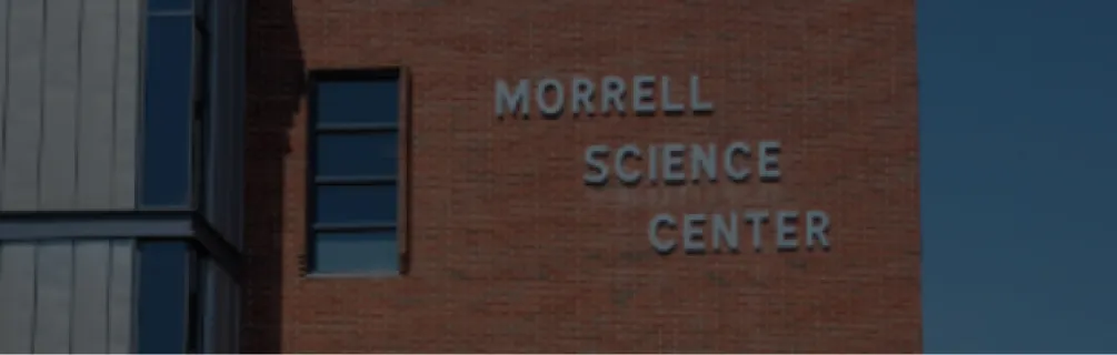 Exterior view of the Morrell Science Center building with metal and brick facade under clear blue sky.