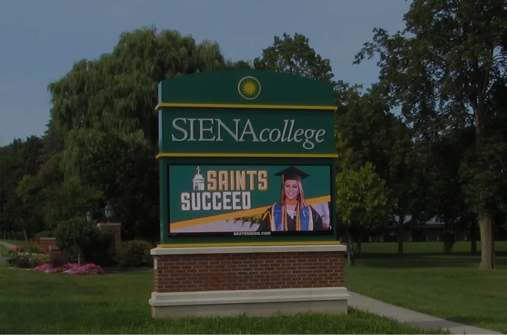 Siena College digital sign featuring a graduate in cap and gown with the slogan "Saints Succeed"