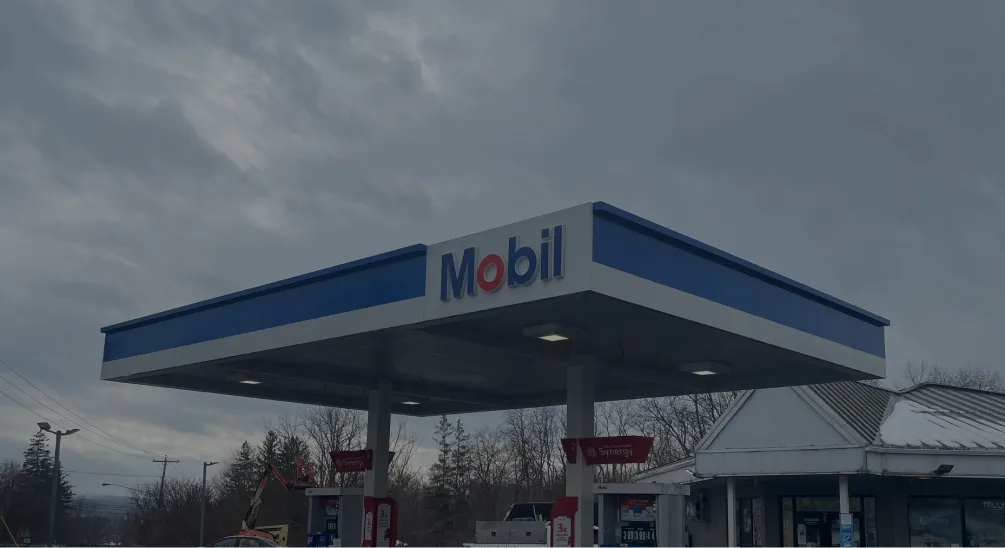 Mobil gas station canopy with blue trim under overcast skies