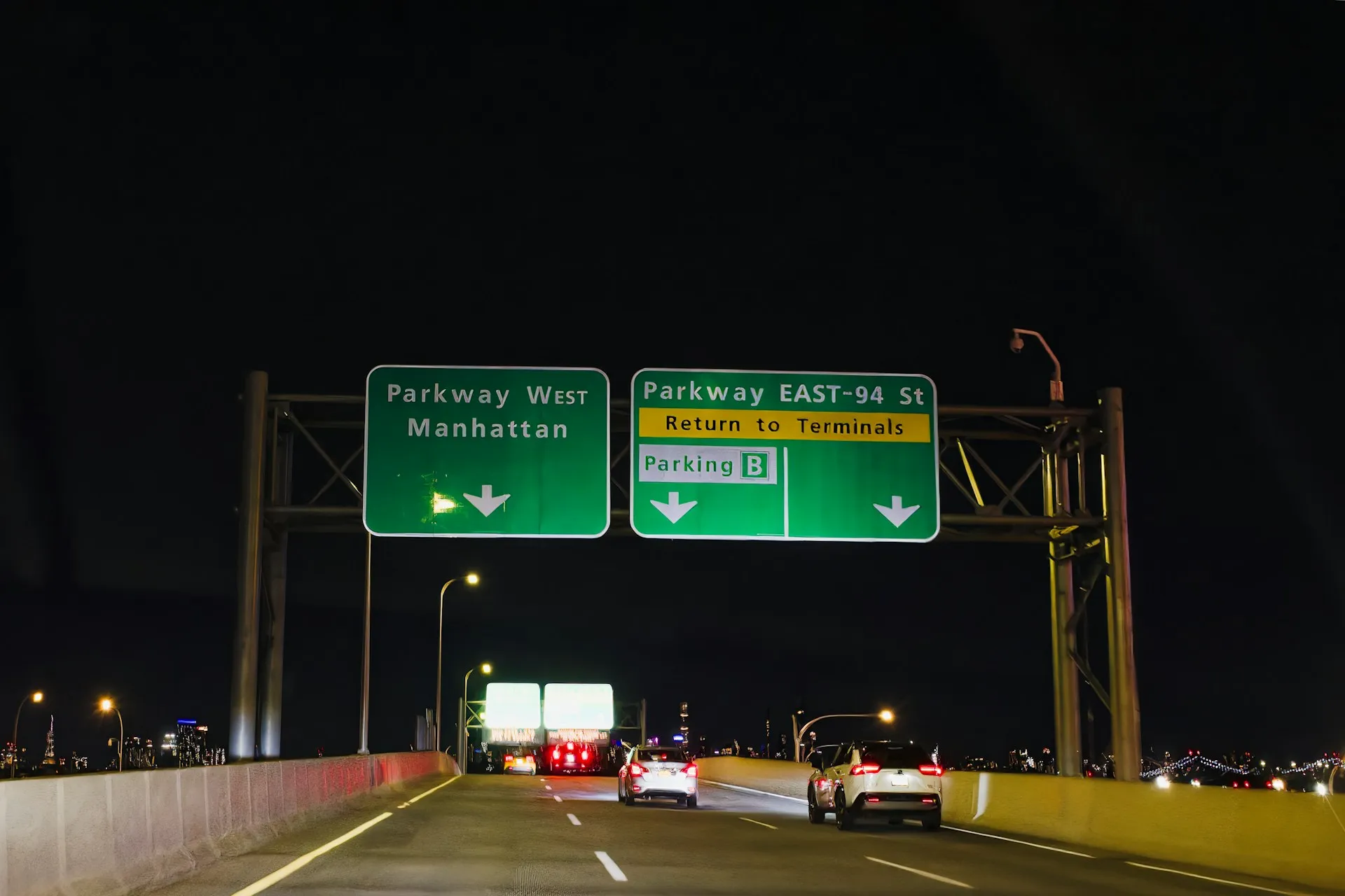 Night highway signs to Manhattan and terminals