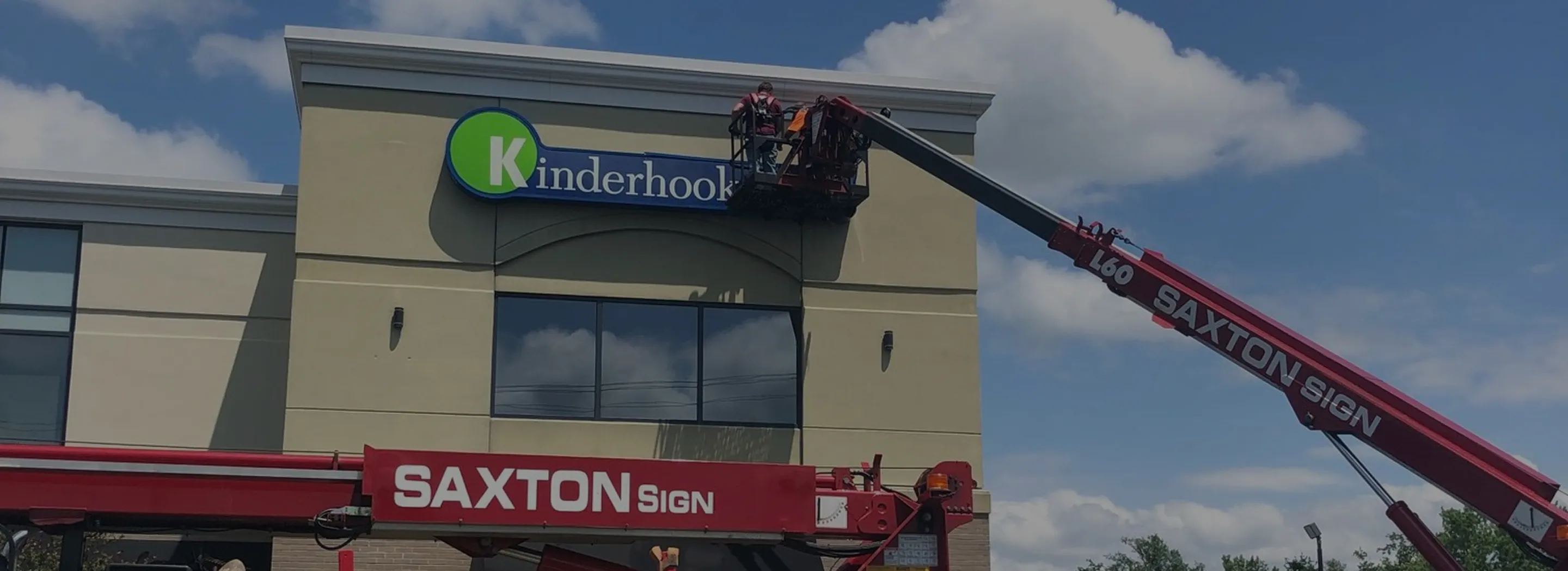 Crane installing Kinderhook sign on building