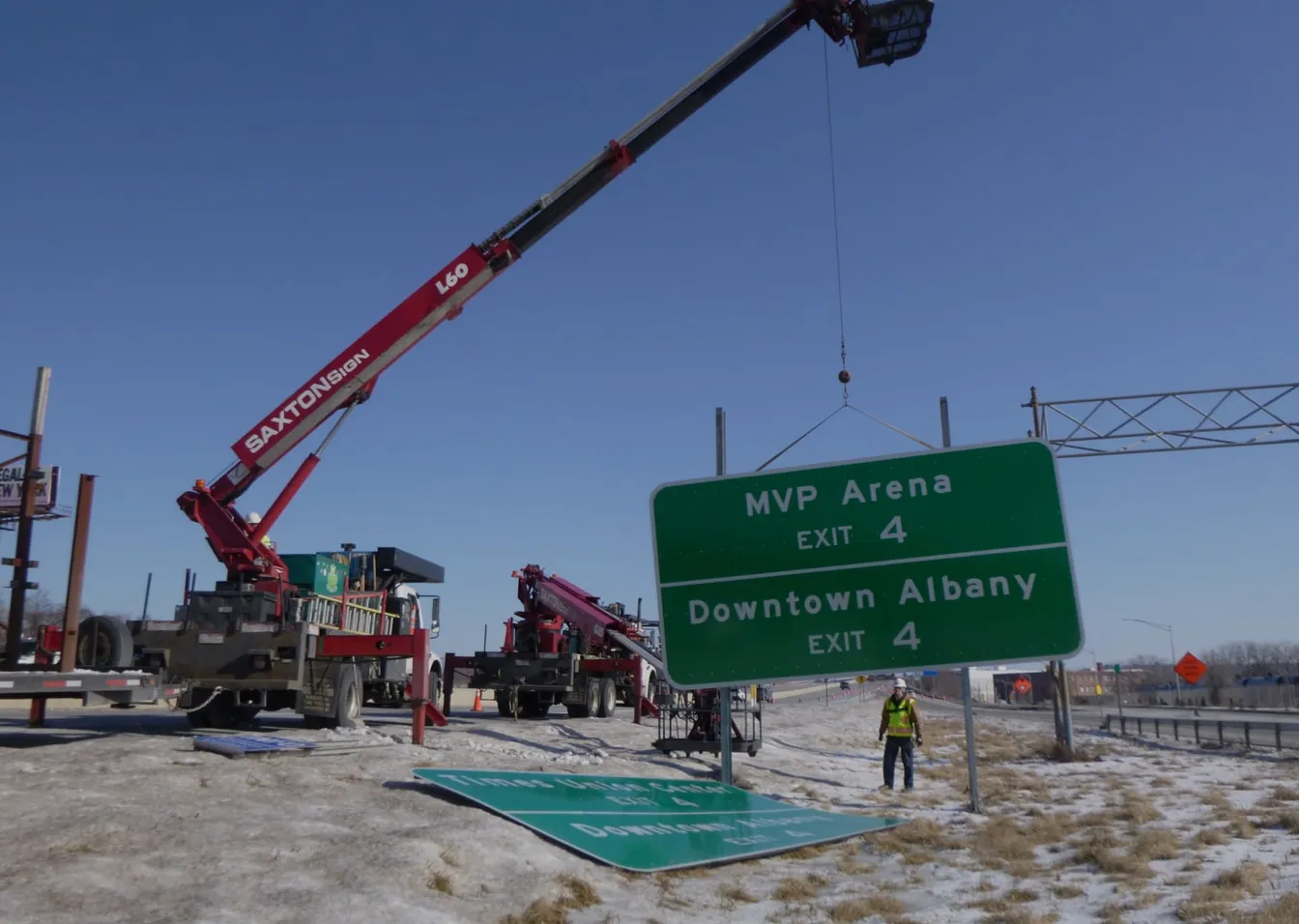 Crane lifting highway sign to Albany