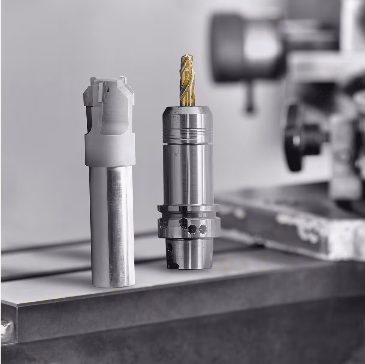 Two metal milling tools on a workbench.