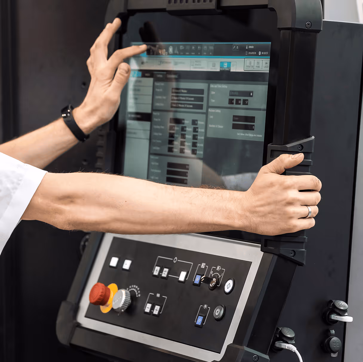 Person operating a CNC machine control panel.