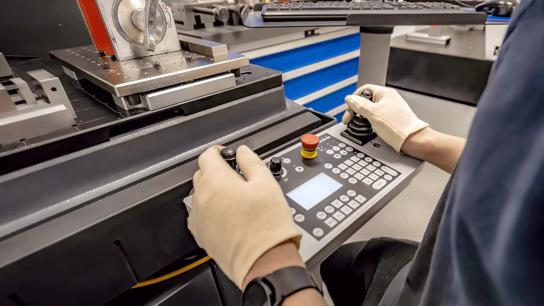 Worker using a control panel to operate a CNC machine.