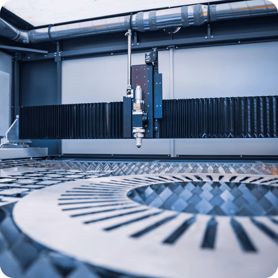 Industrial laser cutting machine working on a large metal sheet.
