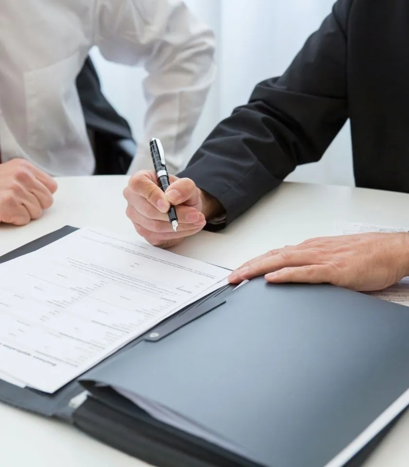 Person completing a printed document with a pen