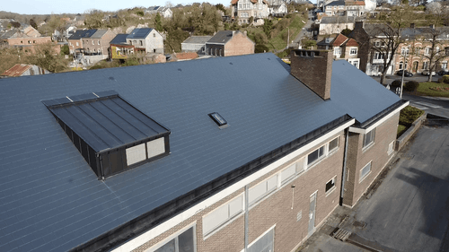 Image d'une toiture en ardoises artificielles imitation ardoises naturelles avec recouvrement des barbacanes en zinc anthracite à joint debout.