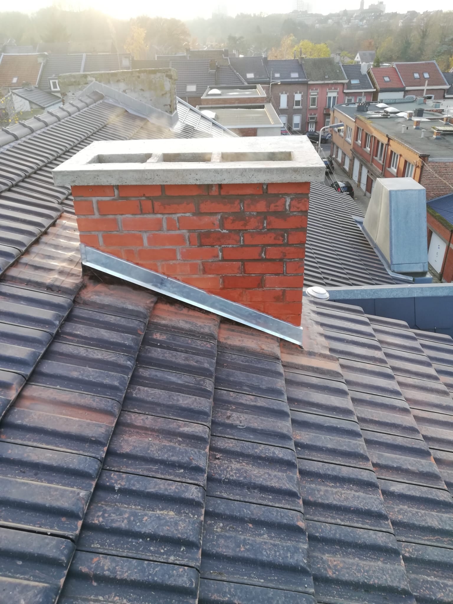 Image d'une souche de cheminée entièrement remaçonnée ainsi que le coulage de la nouvelle dalle de cheminée. 