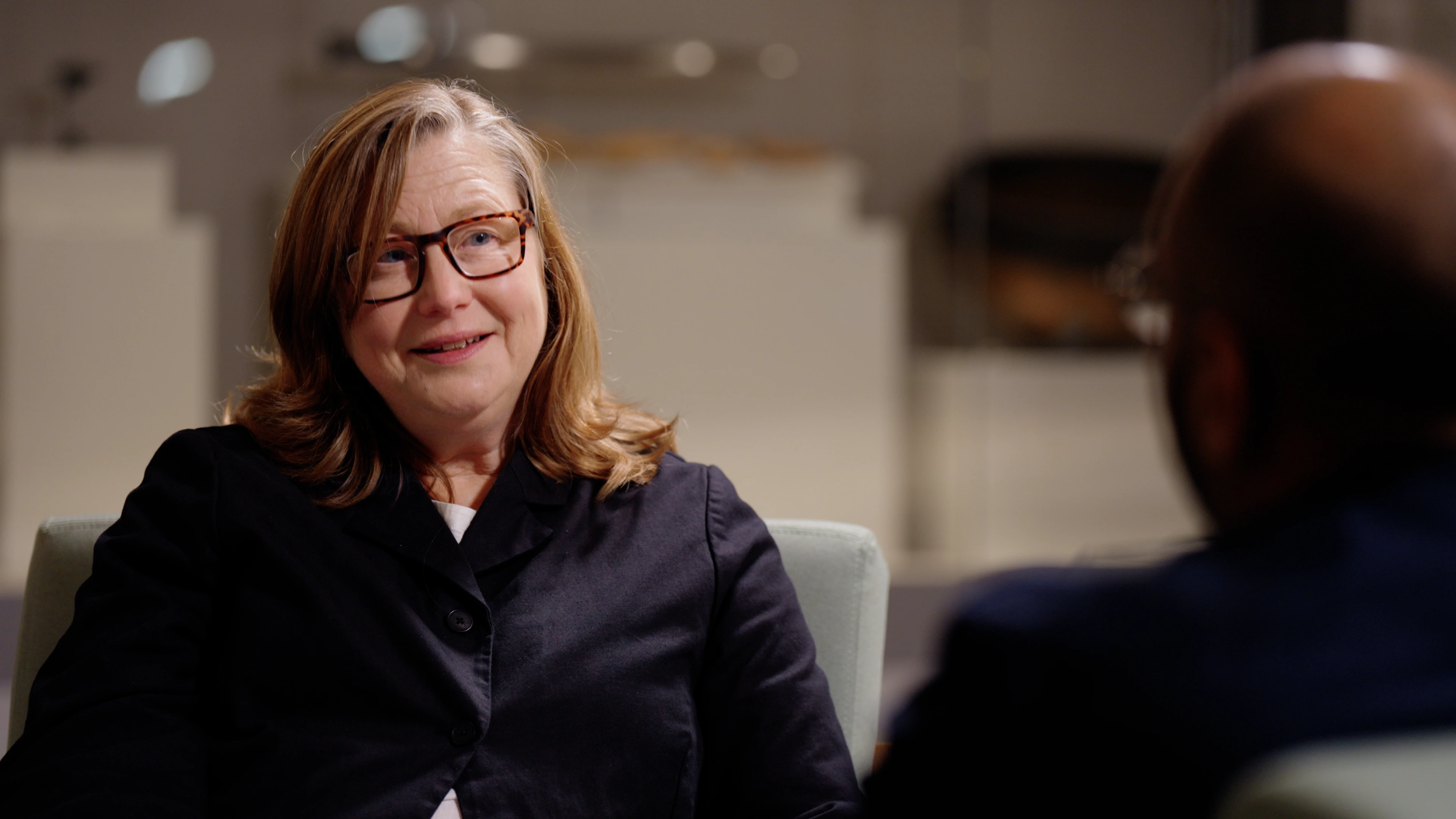 Over-the-shoulder framing of Emma Parker interviewing Akshay Sharma at Jewry Wall Leicester during Rendah Films production