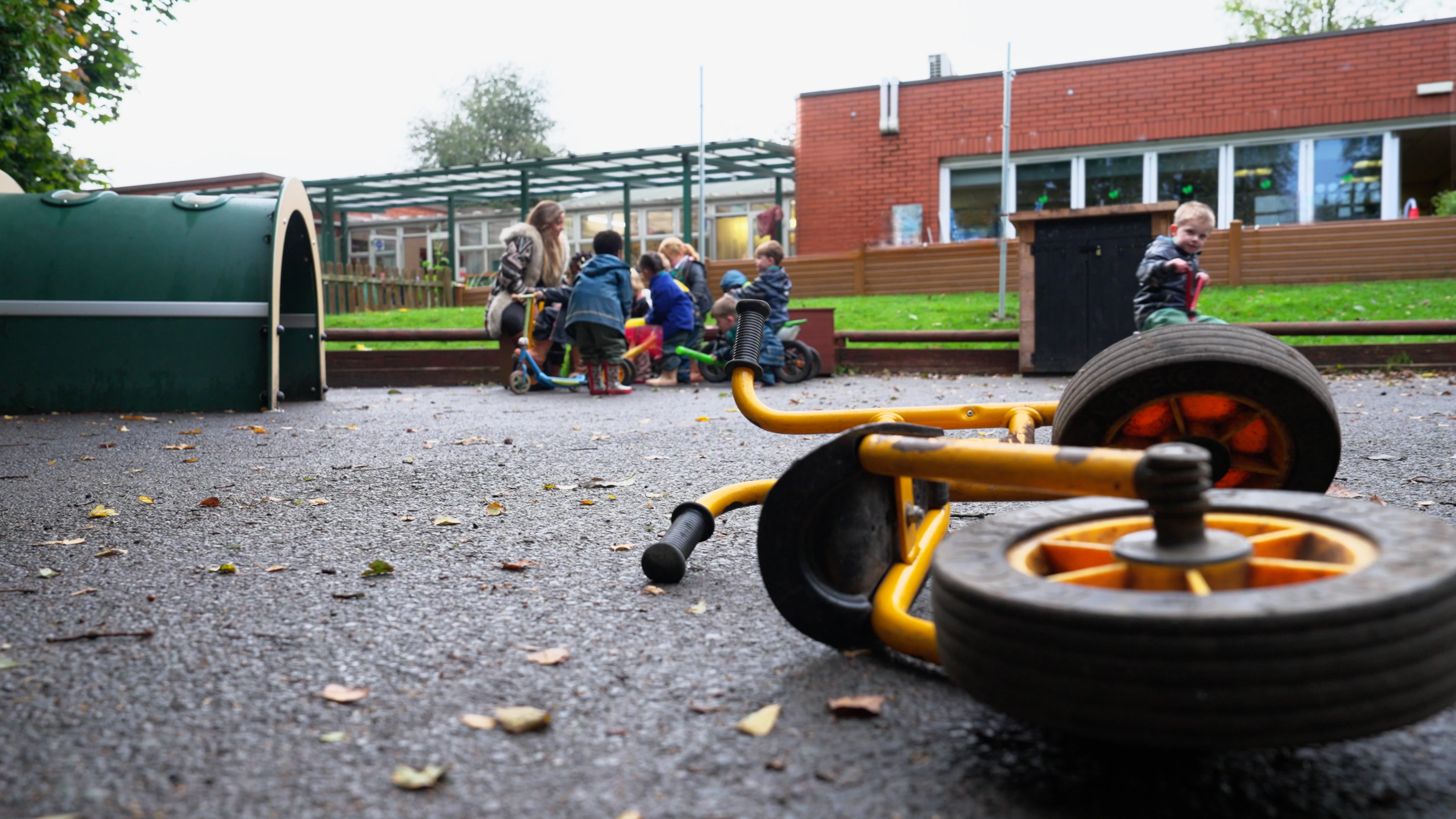 Educational playground environment with children and educator in background. Cinematic depth-of-field shot from “Loop” mini documentary by Rendah Films exploring early childhood environments.